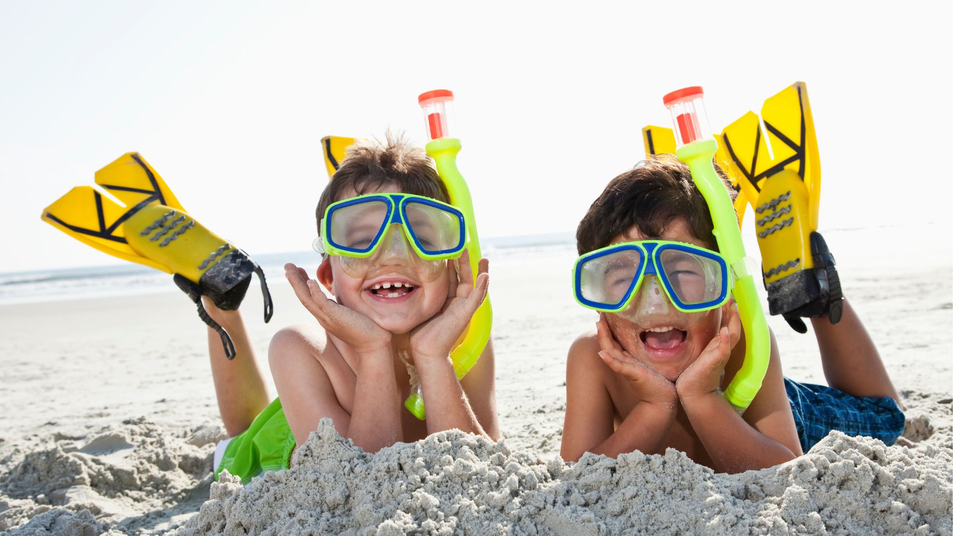 Niños felices con equipo de snorkel en la playa